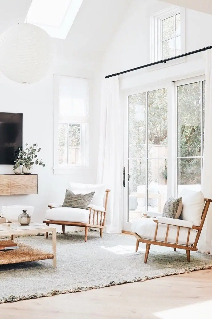 Living room where natural light amplifies wood colors, blending mixed wood tones with airy decor.