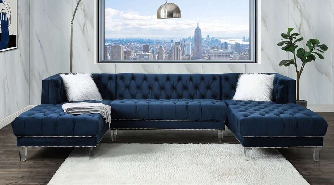 Navy blue living room with a tufted sectional, marble walls, and a stunning city skyline view.