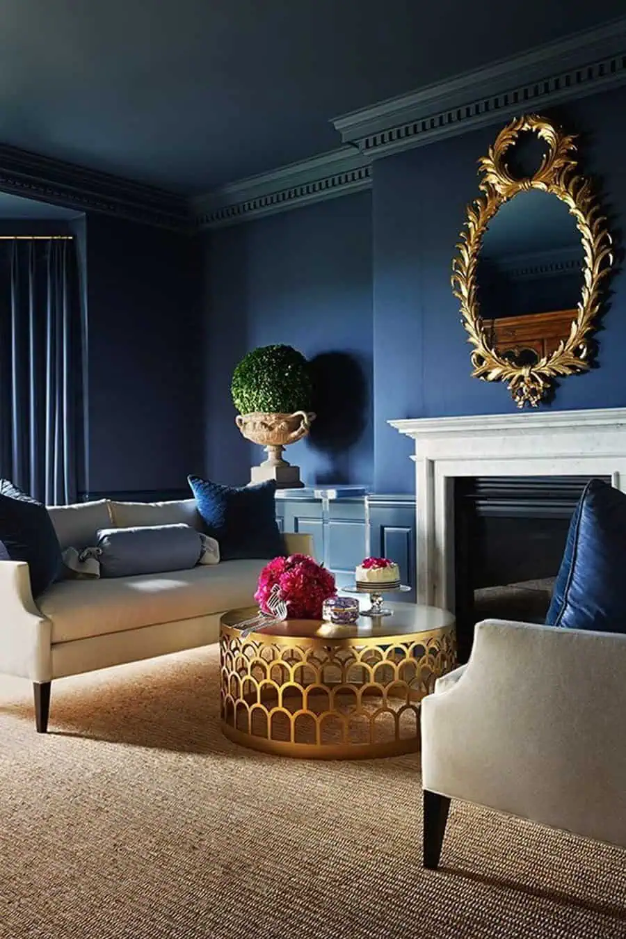 Navy blue living room with vintage brass accents, elegant seating, and a marble fireplace.