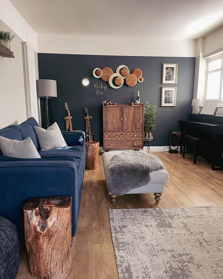 Navy blue living room with a cozy sofa, wooden accents, and farmhouse-inspired wall decor.