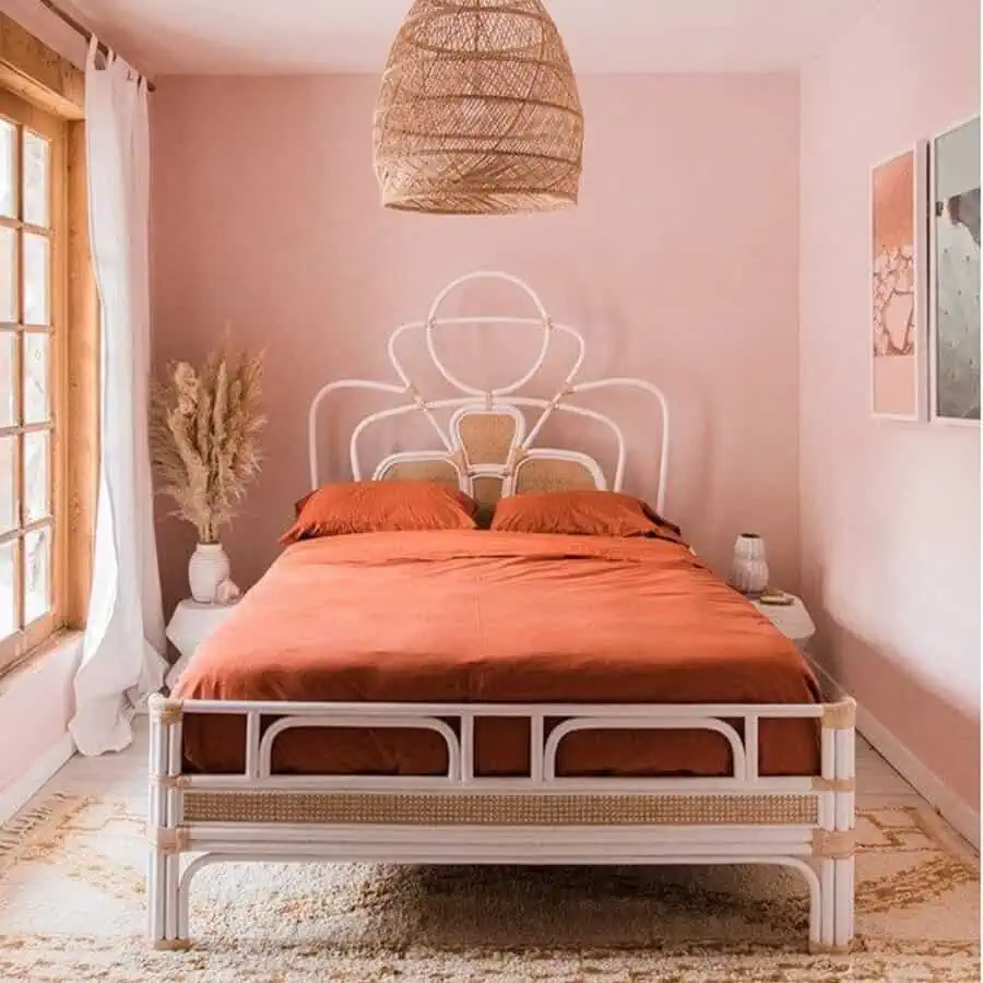 Orange bedroom with bold bedding, rattan accents, pastel walls, and vibrant decor elements.