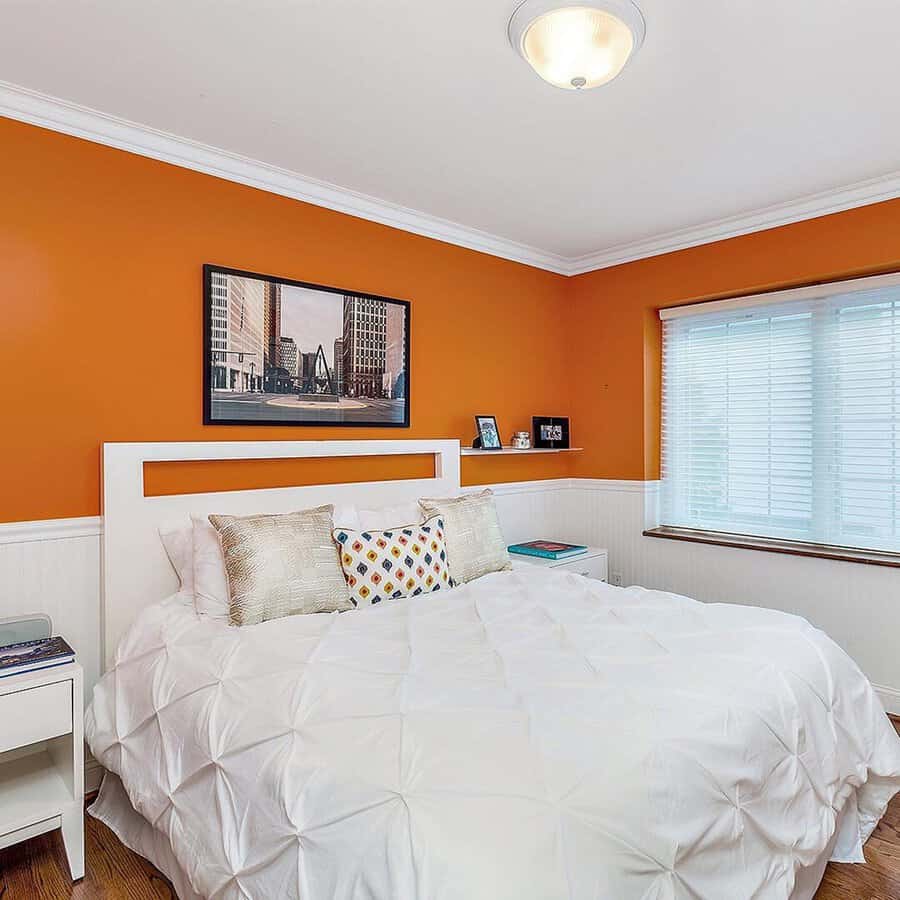 Orange bedroom with white accents, crisp bedding, and minimal decor for a fresh and airy look.