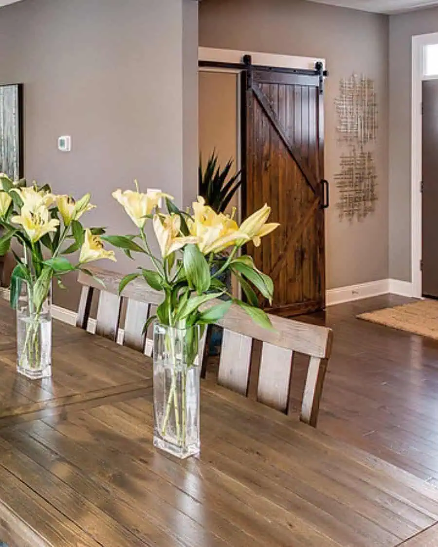 Dining room with unique wood stains, a rustic barn door, and warm contrasting tones.