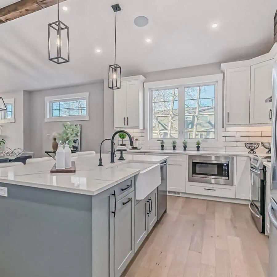 Modern farmhouse kitchen with white cabinets, a large island, and black pendant lighting.