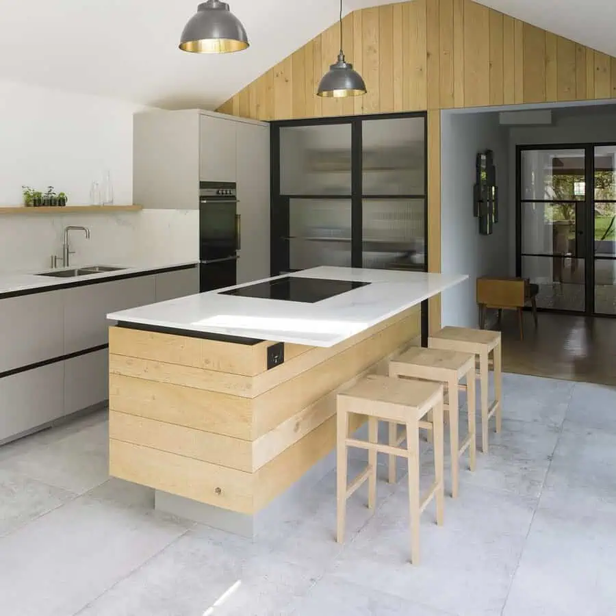 Simple kitchen design with a wood and marble island, light grey cabinets, and ample natural light.