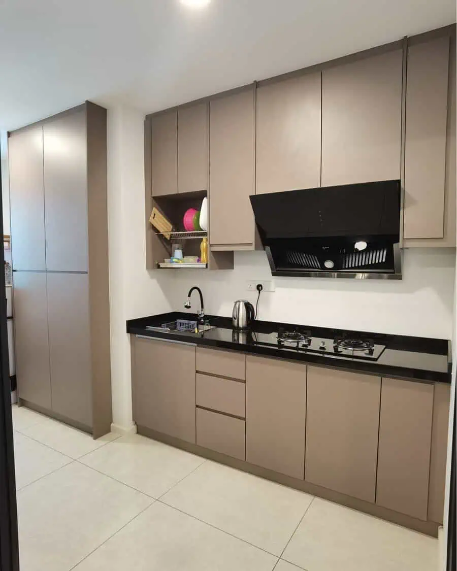 Simple kitchen design with taupe cabinetry, black countertops, and easy-to-maintain smooth surfaces.