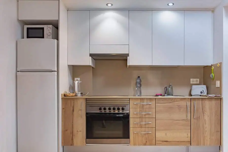 Simple kitchen design with white cabinets, wood accents, and modern appliances for a warm look.