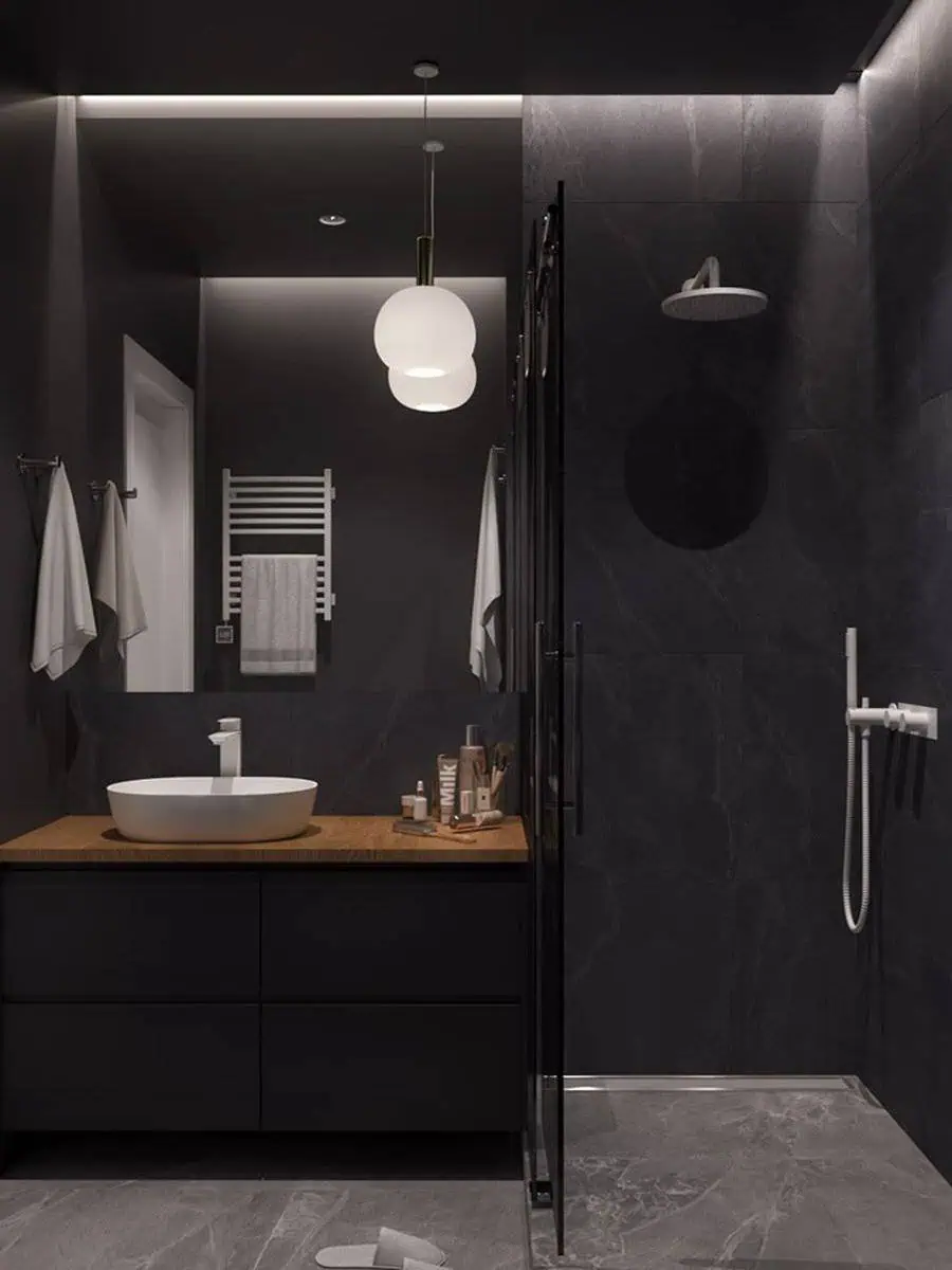 Modern black bathroom with a wood vanity, vessel sink, and soft ambient lighting.