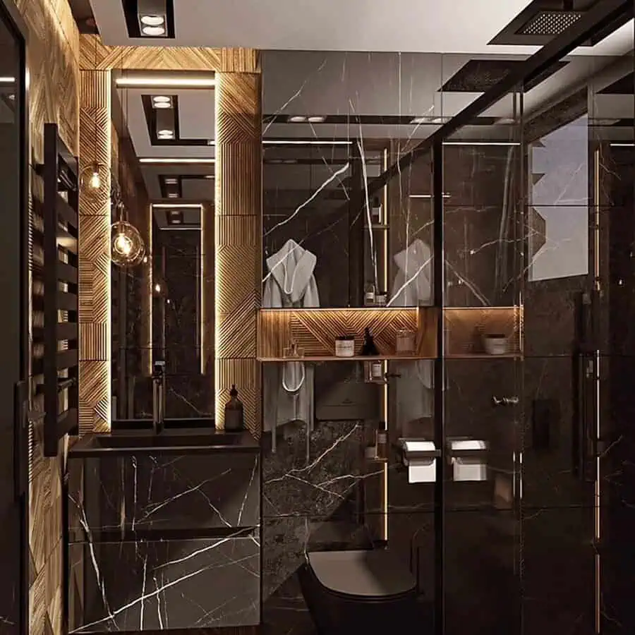 Luxury black bathroom with marble walls, gold accents, and warm ambient lighting.