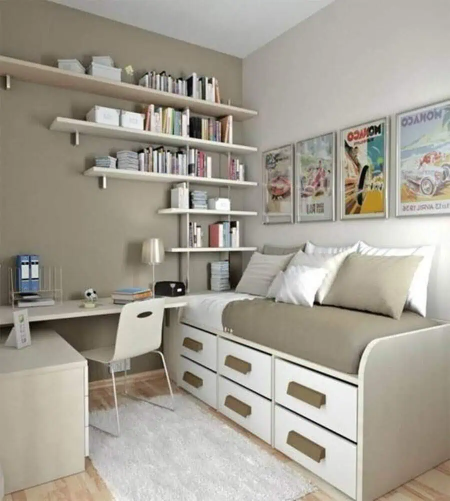 Small grey and white living room with a storage sofa, wall shelves, and a compact study desk.