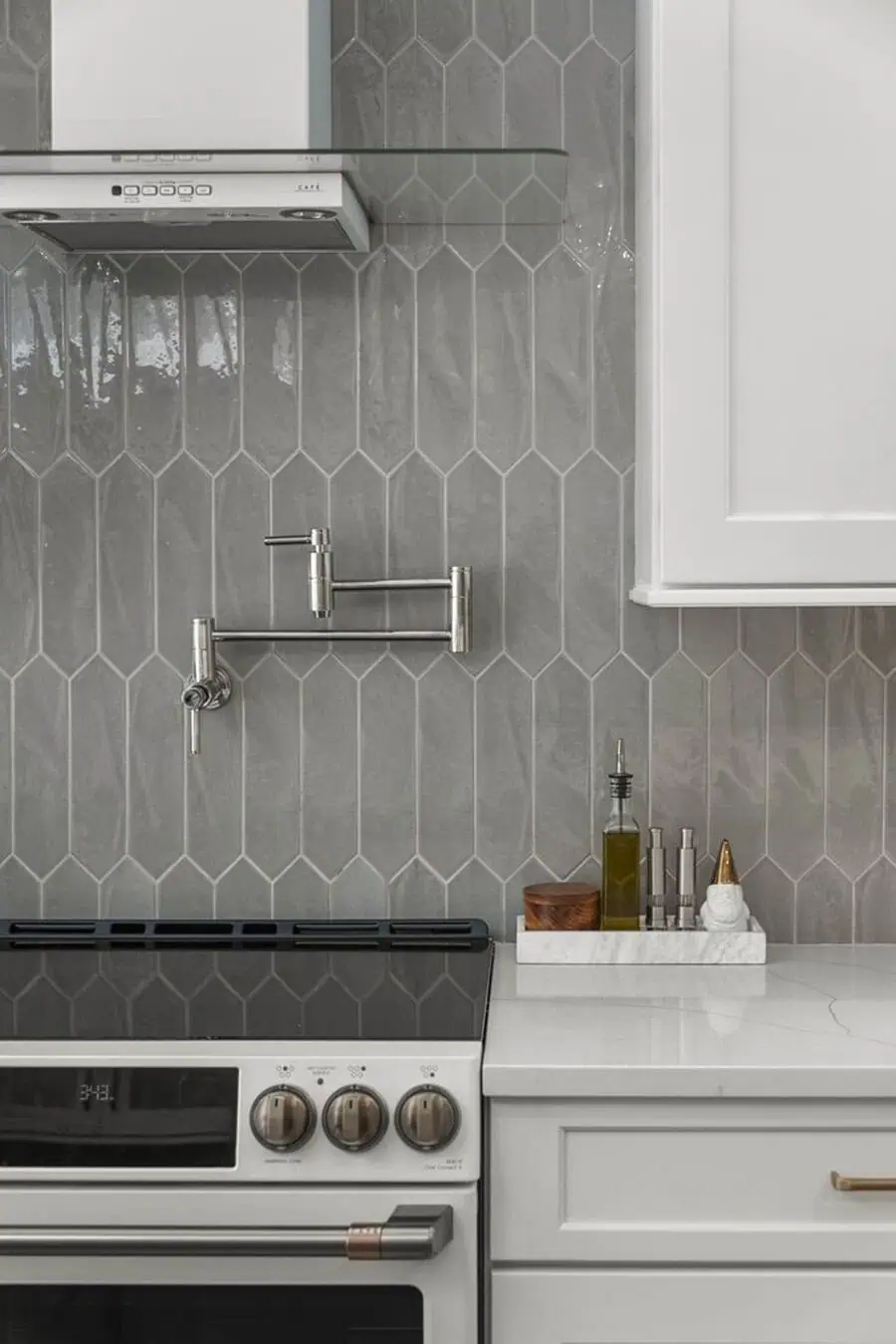 Textured gray tile backsplash adds depth and a modern touch to sleek white cabinets for a stylish kitchen.