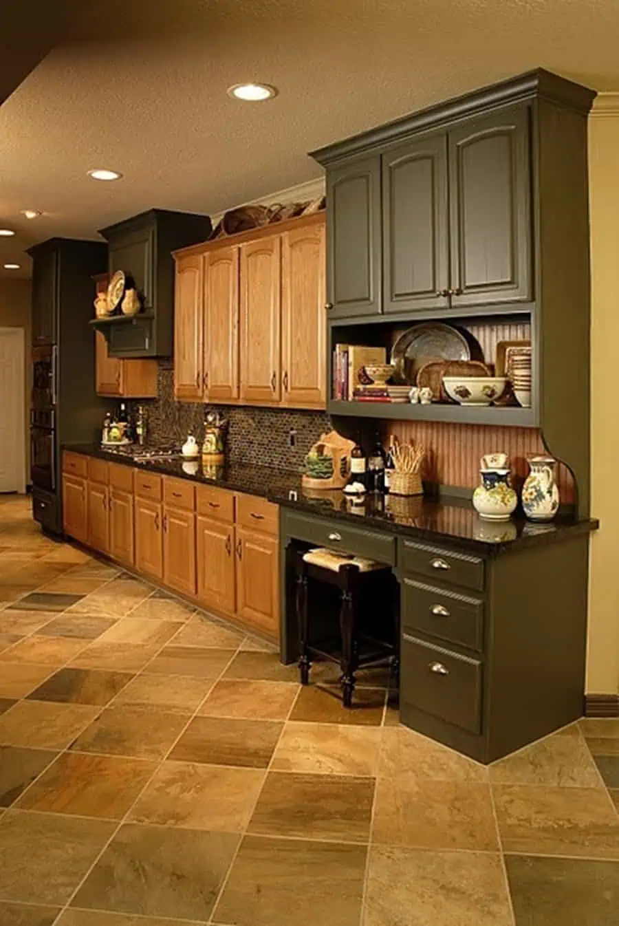 Traditional kitchen with two-tone cabinets, warm wood tones, and dark green accents.