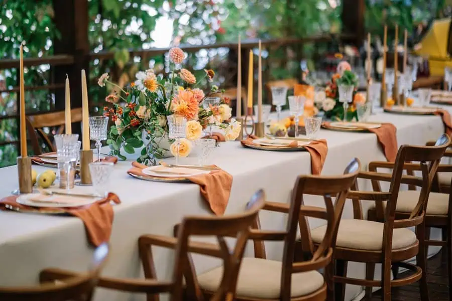 Wedding and housewarming joint celebration with an elegantly decorated outdoor table, flowers, and candles.