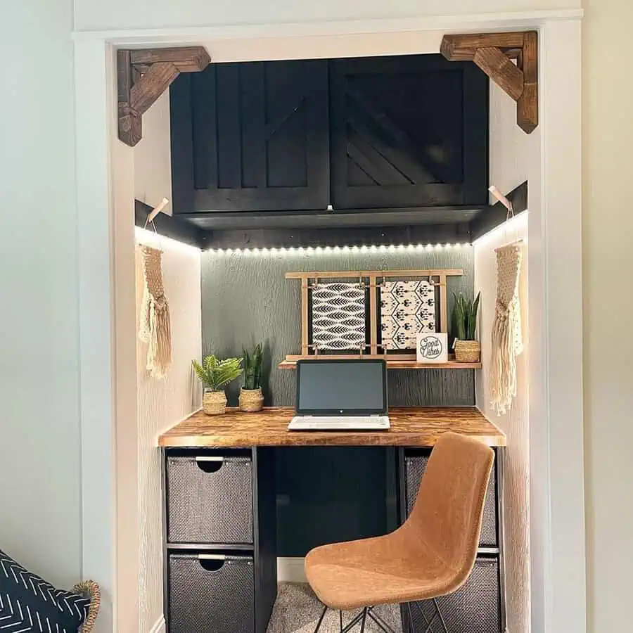 Closet turned into a boho desk nook with barn-door cabinets, LED lighting, and potted plants for a cozy home office.