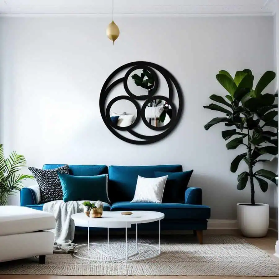 Bold circular mirror with overlapping rings above a teal sofa, paired with a fiddle leaf plant and minimalist decor in a modern living room.