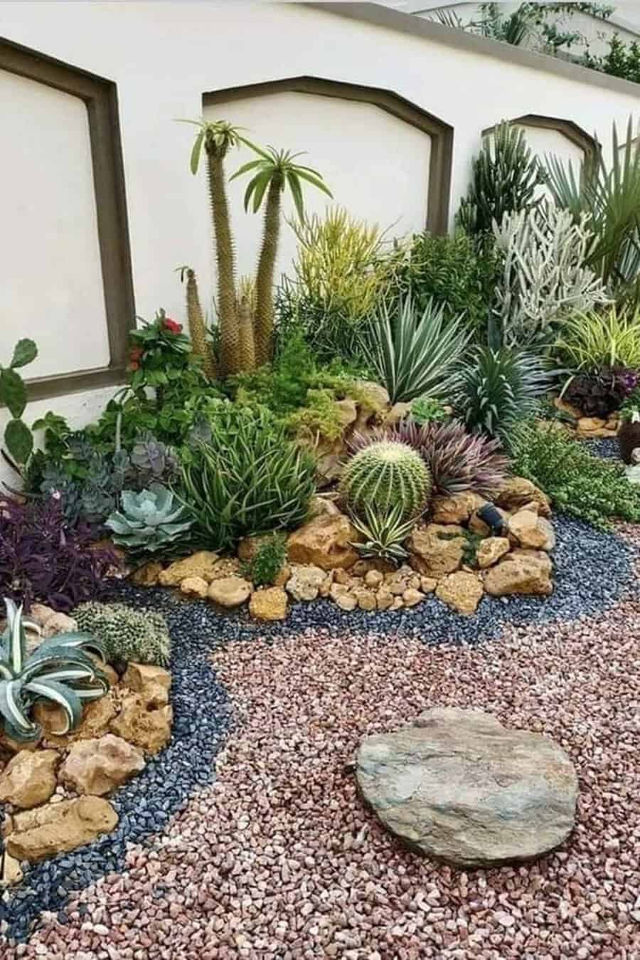 Garden with multi-colored gravel, boulders, and lush cacti and succulents arranged to create dynamic, layered beds.