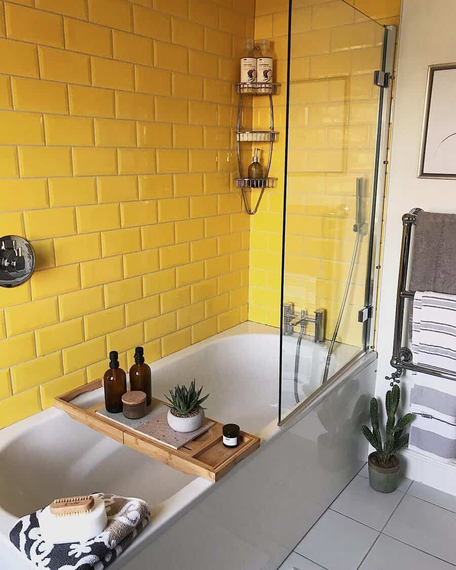Bathroom with yellow subway tiles, a bamboo bath tray, and a glass shower partition for a lively, clean design.