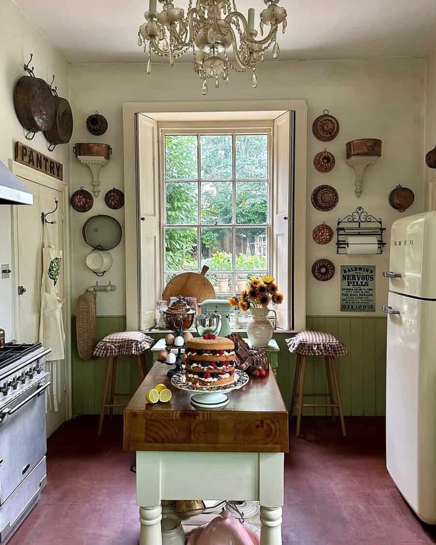 Cozy kitchen nook with vintage copper pans, a chandelier, butcher-block island, and a classic fridge for a warm, nostalgic feel.