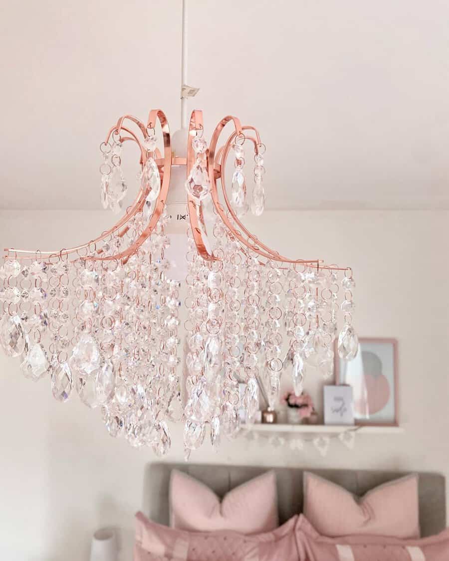 Rose gold chandelier with cascading crystals adds a glamorous and elegant touch to a soft pink bedroom.
