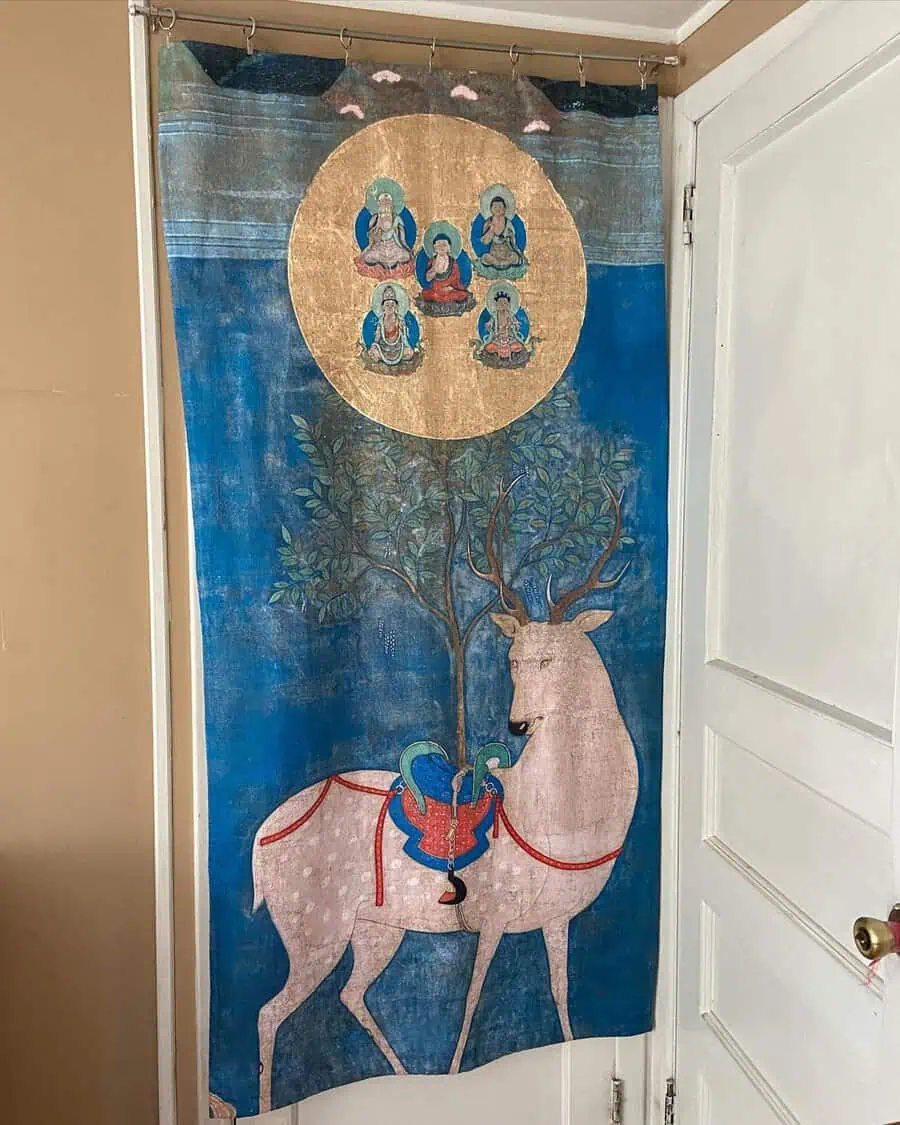 Beautiful tapestry with a deer, Buddhist imagery, and tranquil colors, adding a unique spiritual touch to the space.