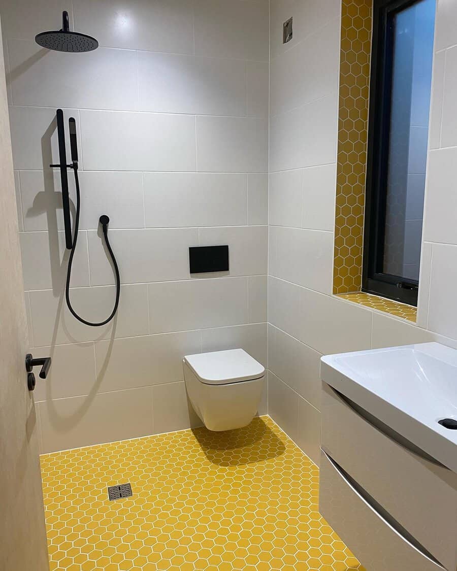 Bathroom with yellow honeycomb floor tiles, white walls, black shower fixtures, and modern minimalist design.