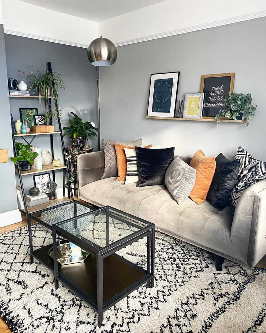 Living room corner with a gray sofa, layered pillows, metallic floor lamp, and a black-and-white patterned rug for warmth and texture.