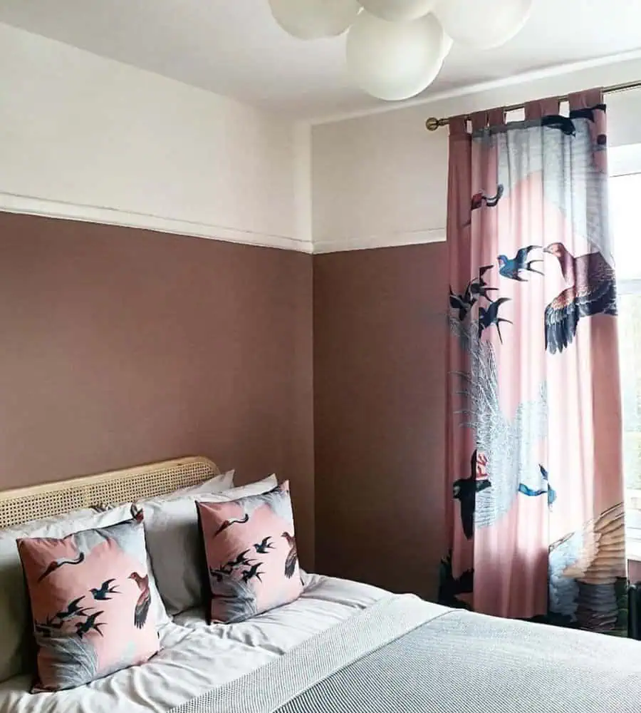 Bold patterned curtains with crane motifs add movement and elegance to a stylish bedroom with warm, earthy tones.