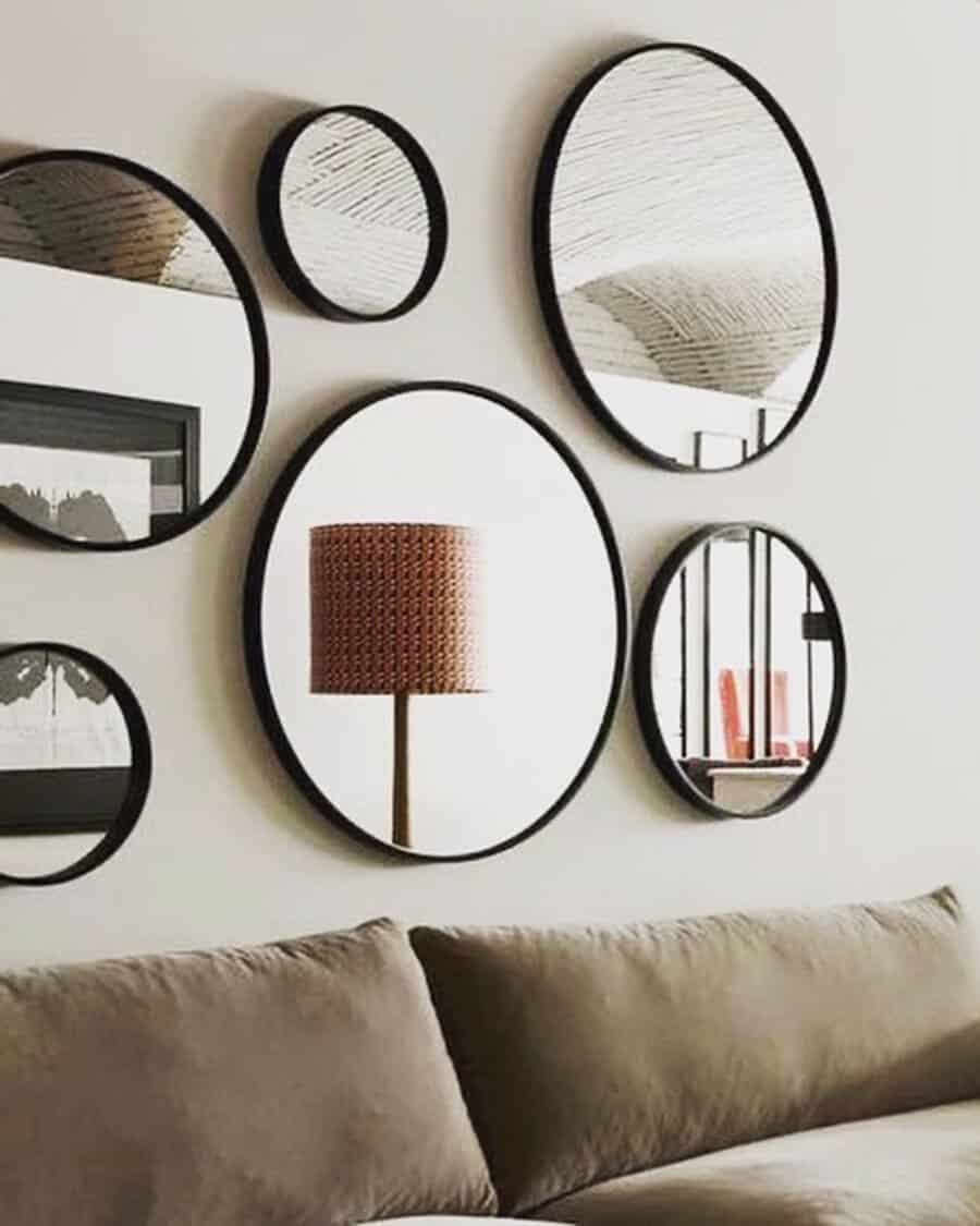 A collection of round mirrors arranged above a sofa, adding style and depth to a minimalist living room.