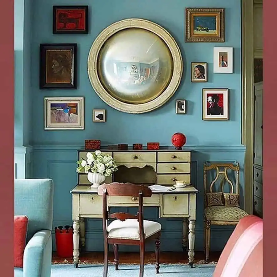 Round mirror with eclectic artwork and vintage furniture in a cozy, artistic room.