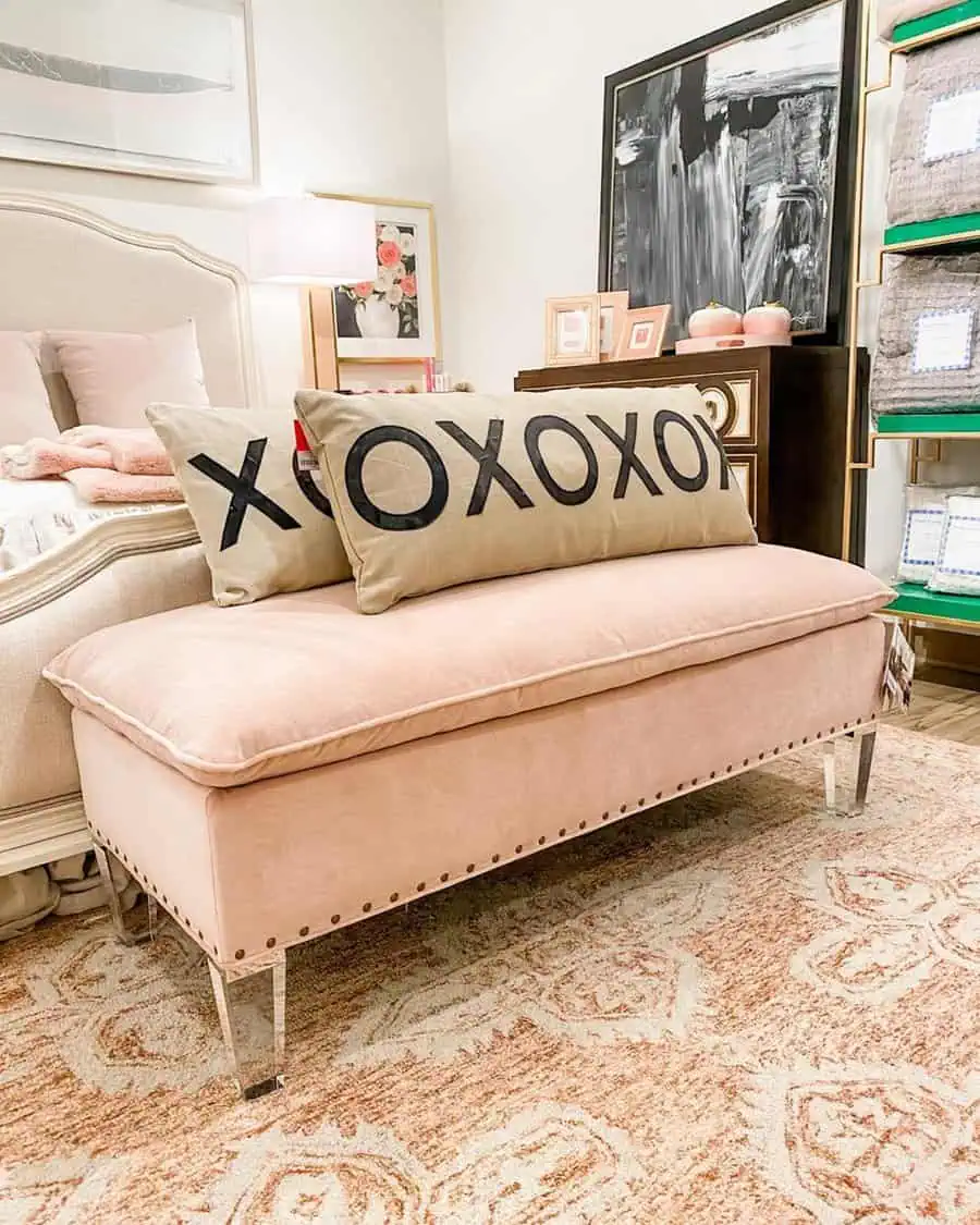 Bedroom sitting area with a blush velvet bench, acrylic legs, soft neutral tones, and feminine decor for a cozy and elegant look.