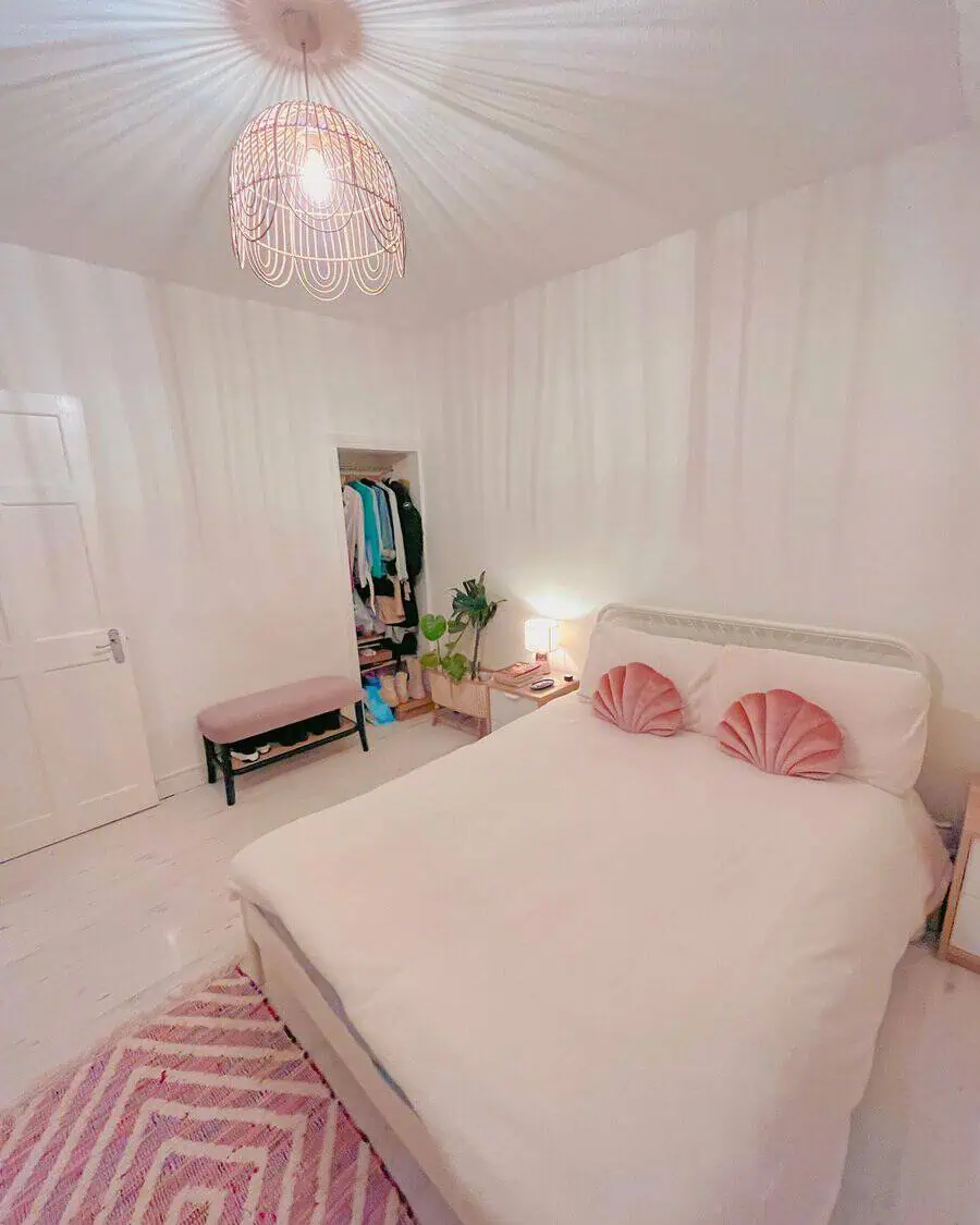 Textured pink rug adds warmth and style to a cozy bedroom with soft neutral tones.