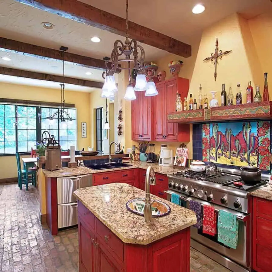 Spanish-style kitchen with red cabinets, a colorful tile backsplash, brick flooring, wood beams, and warm yellow walls.