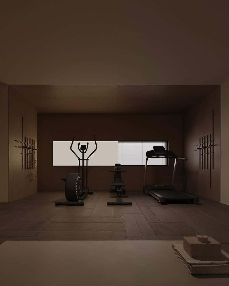 Minimalist home gym with wood walls, subdued lighting, and essential exercise equipment for a calm, focused workout environment.