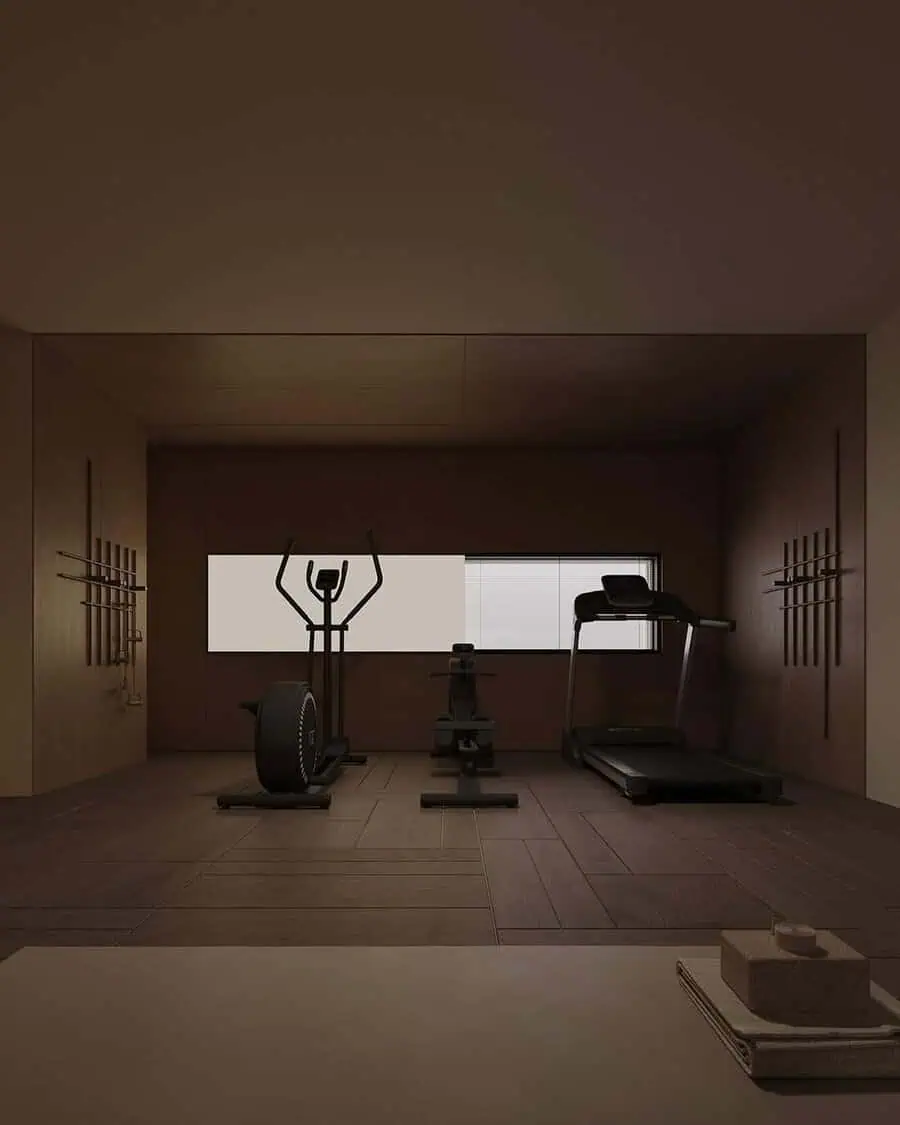 Minimalist home gym with wood walls, subdued lighting, and essential exercise equipment for a calm, focused workout environment.