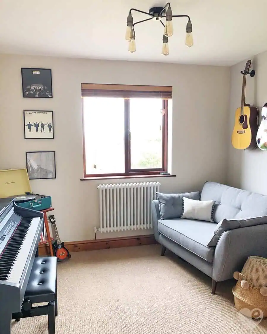 Music room with a loveseat, wall-mounted guitars, digital piano, and album art creating a cozy, retro-inspired retreat.