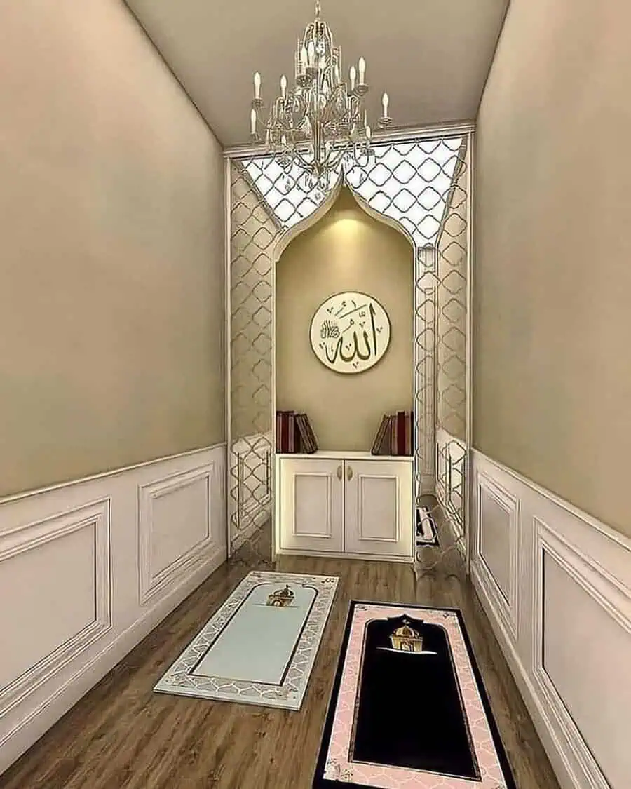 Narrow prayer area with an arched niche, chandelier, paneling, and prayer mats for a calm, spiritual retreat.