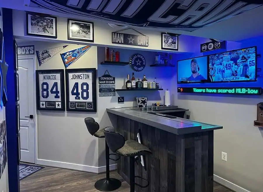 Sports-themed man cave featuring Dallas Cowboys décor, bar area, and multiple screens for the ultimate game-day experience.