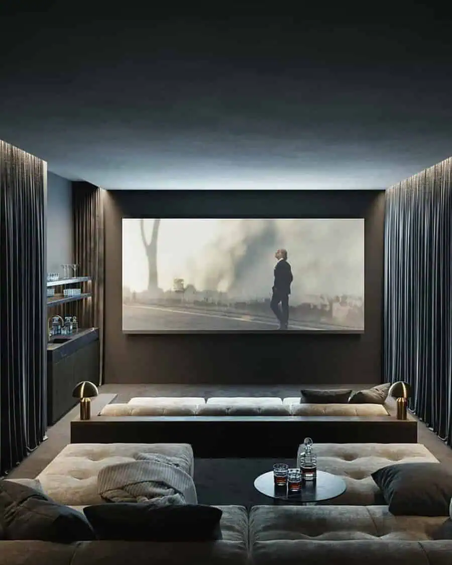 Dark home theater with plush sectional seating, tall curtains, and a large screen for a truly immersive viewing experience.