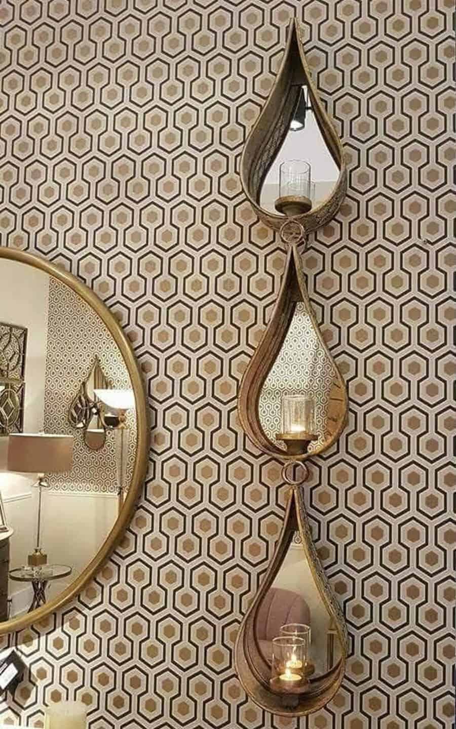 Teardrop-shaped mirrors with candle holders above a round mirror, set against a geometric patterned wallpaper for a stylish, modern look.